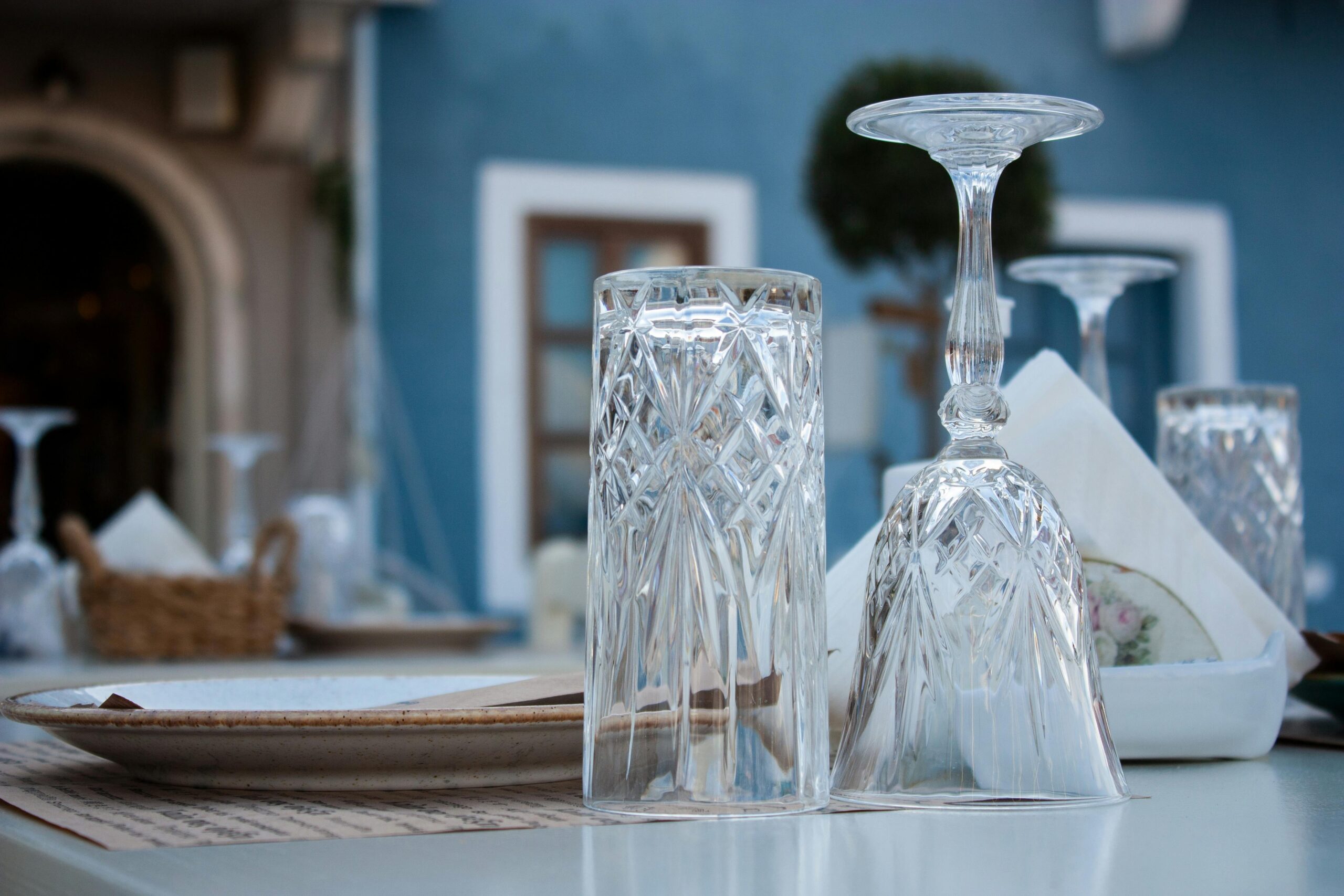 Close-up of crystal glassware on a table at an outdoor restaurant in Fiskardo, Greece.